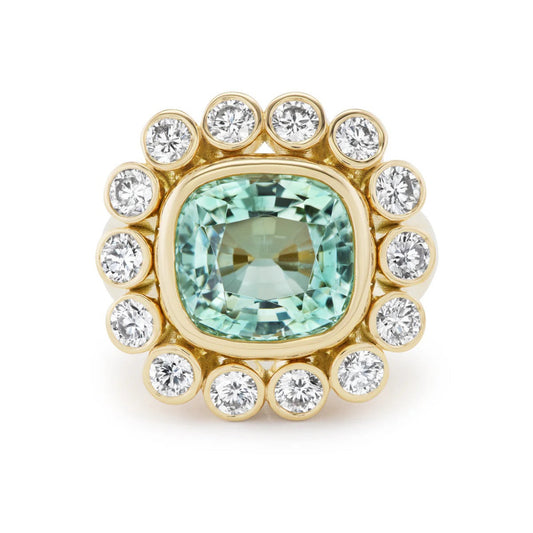 Gold ring with a green gemstone and smaller diamonds on a white background