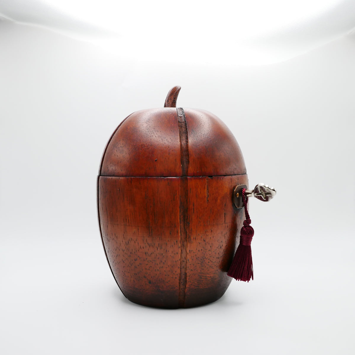 Georgian melon tea caddy showing the oval brass escutcheon, working lock, key and silk tassel