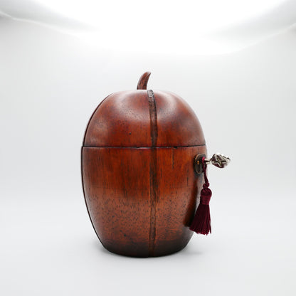 Georgian melon tea caddy showing the oval brass escutcheon, working lock, key and silk tassel