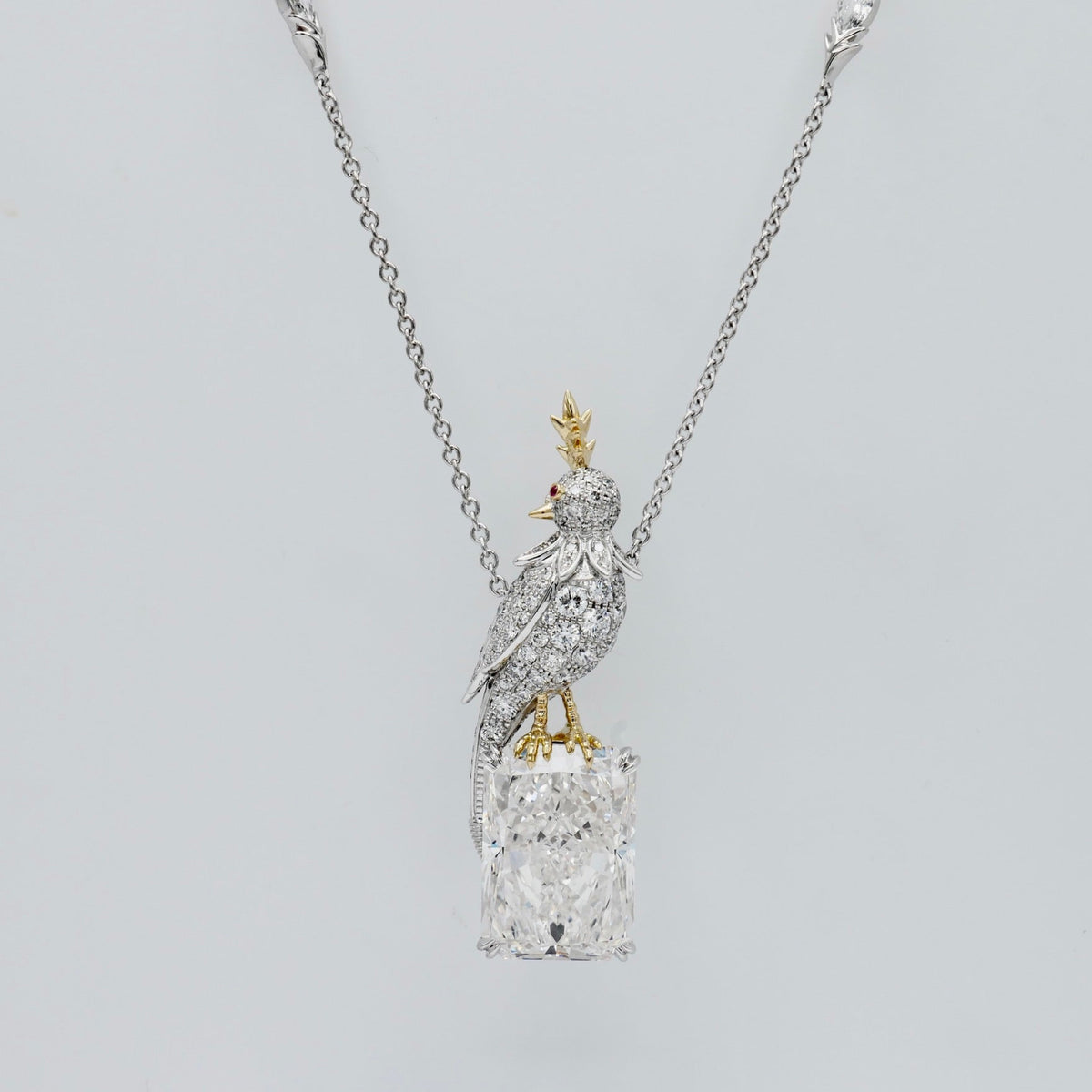 Bird necklace with an 18 carat radiant cut lab grown diamond and a pavé moissanite bird in platinum and 18K gold